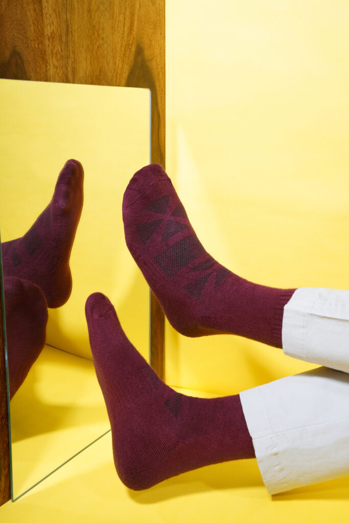 Close-up of a pair of shoes being captured by a 360 rotating camera, showcasing the socks from all angles.